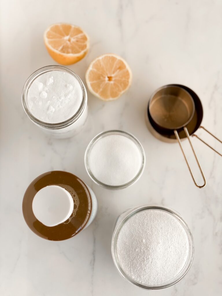 overhead shot of homemade laundry detergent ingredients on white marble backdrop