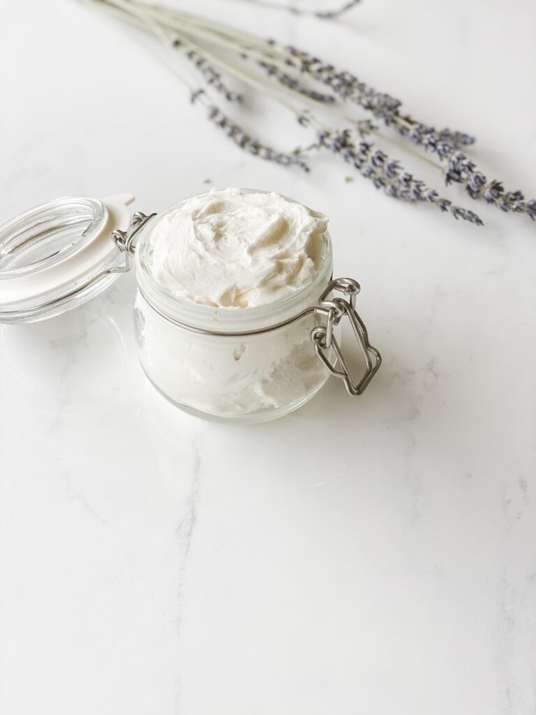 white marble backdrop with glass jar of natural body butter lavender in background