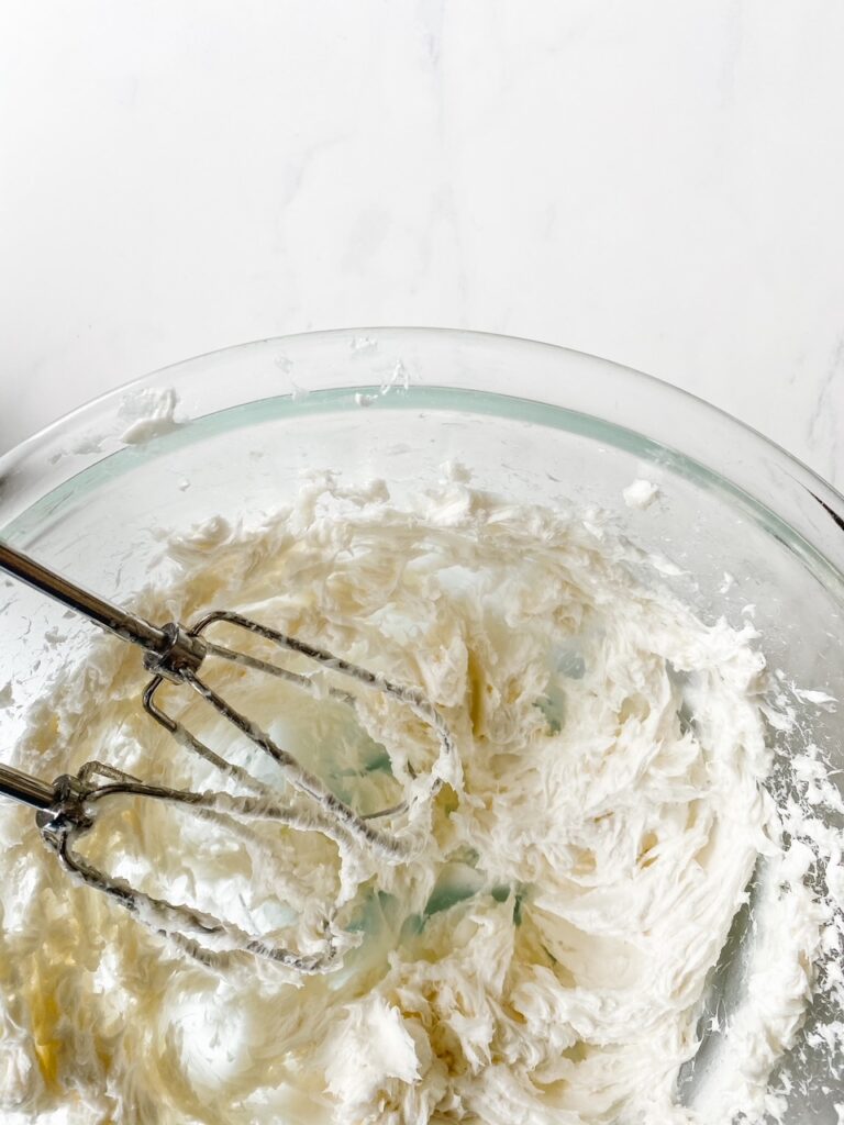 shea butter and coconut oil whipped in a glass bowl with hand mixer