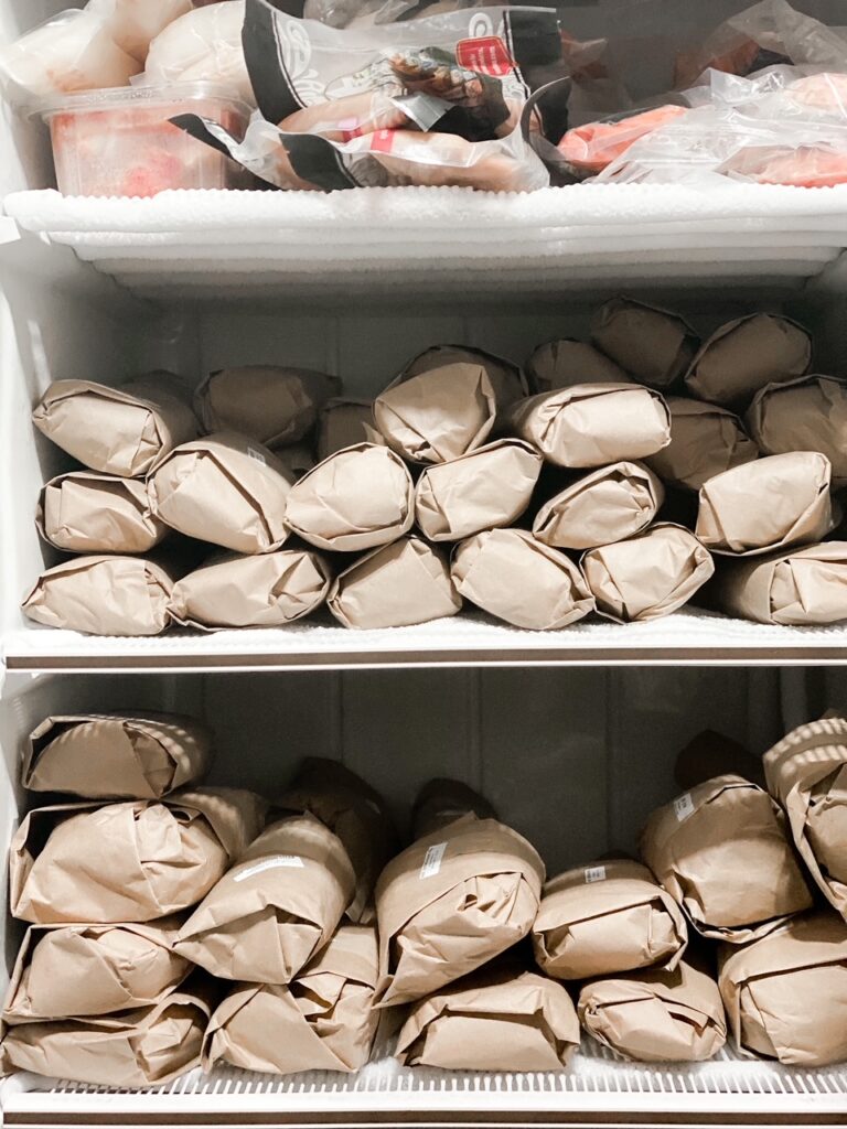 stand up freezer filled with grass fed meat wrapped in paper and wild seafood